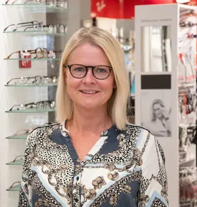 Portrett av optikerassistent Marthe Stine Skrataas foran en brillevegg